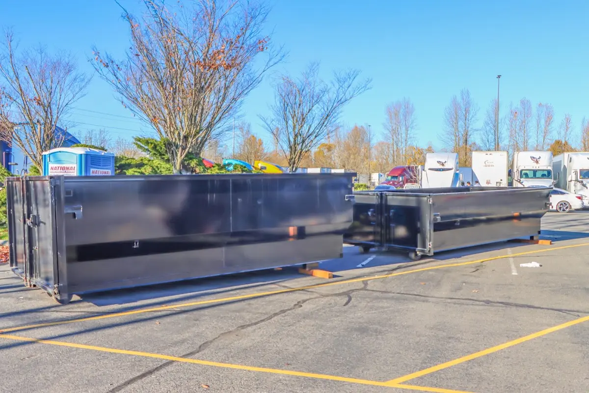 Professional dumpster rental service with roll-off container on residential driveway in Hiawatha